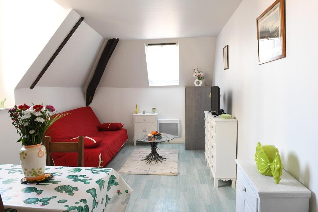 a living room with a red couch and a table at Le Verdier in Dieppe