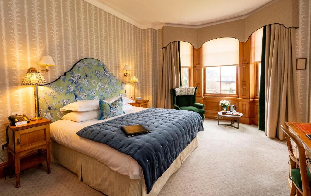 um quarto com uma cama grande e uma cabeceira azul em The Jockey Club Rooms em Newmarket