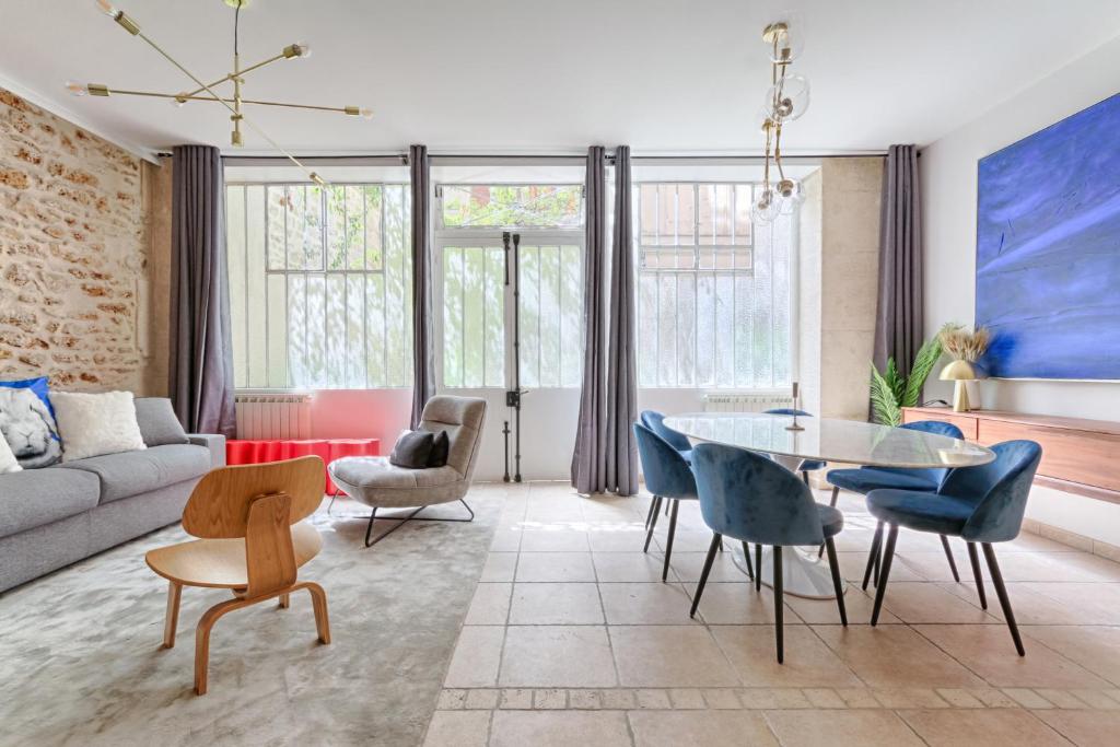 ein Wohnzimmer mit einem Sofa, einem Tisch und Stühlen in der Unterkunft Splendid Parisian Flat 5P - Montorgueil in Paris