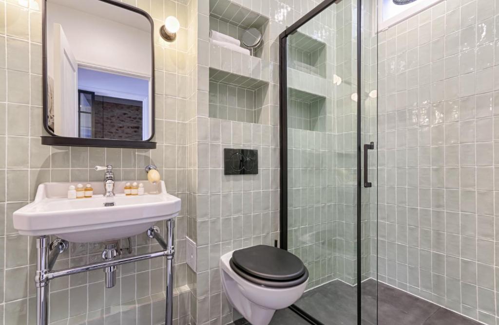 ein Bad mit einem WC, einem Waschbecken und einer Dusche in der Unterkunft Splendid Parisian Flat 5P - Montorgueil in Paris