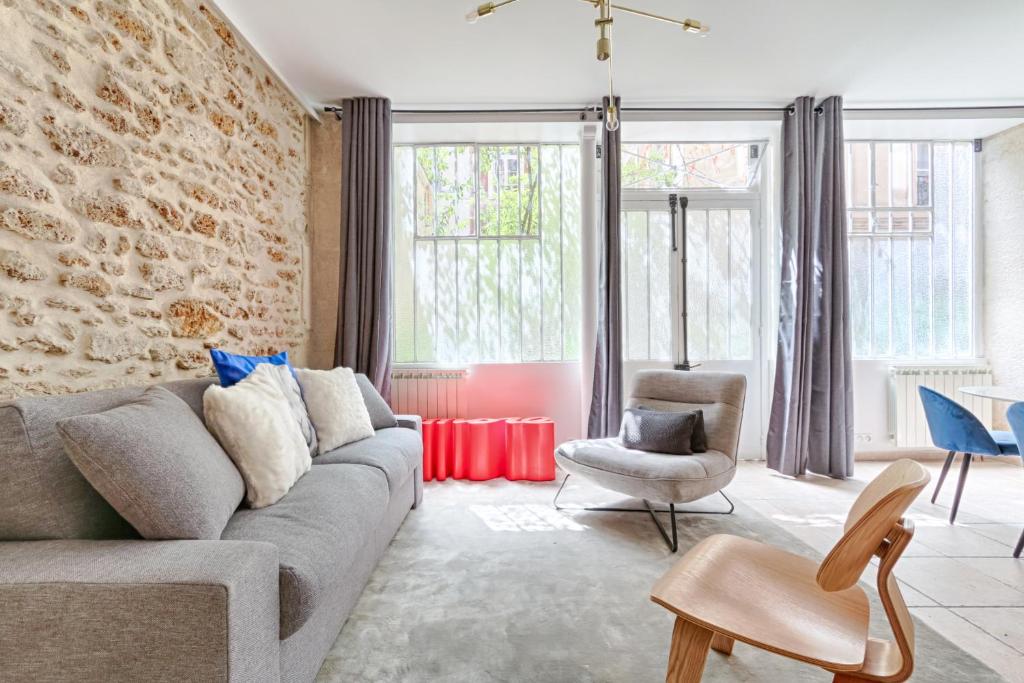 ein Wohnzimmer mit einem Sofa und einem Stuhl in der Unterkunft Splendid Parisian Flat 5P - Montorgueil in Paris