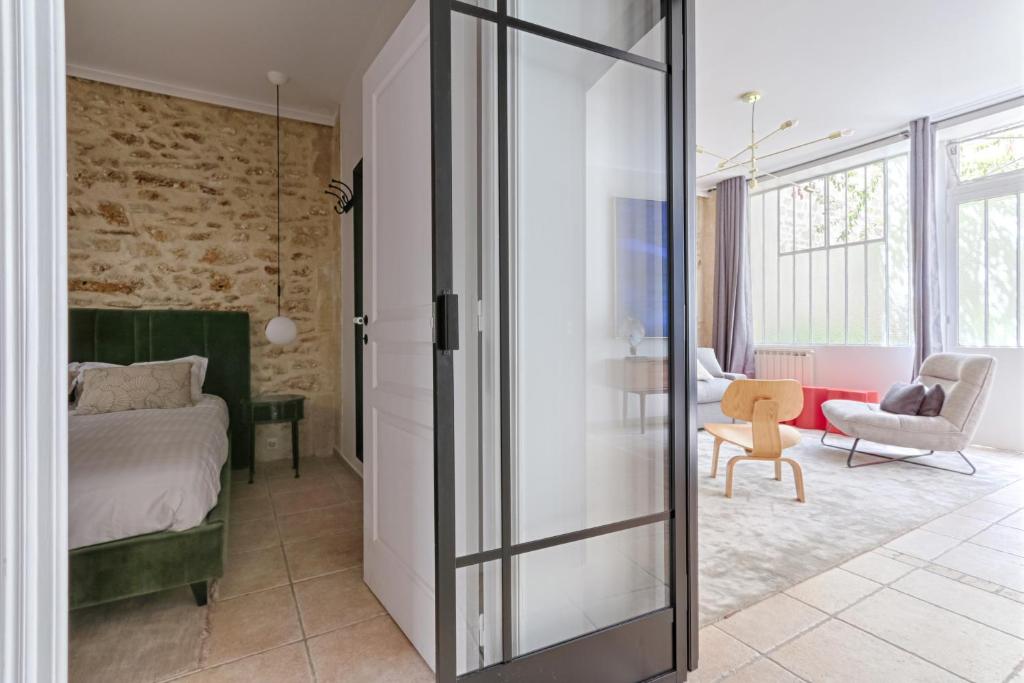 Schlafzimmer mit einem Bett und einer Glasschiebetür in der Unterkunft Splendid Parisian Flat 5P - Montorgueil in Paris