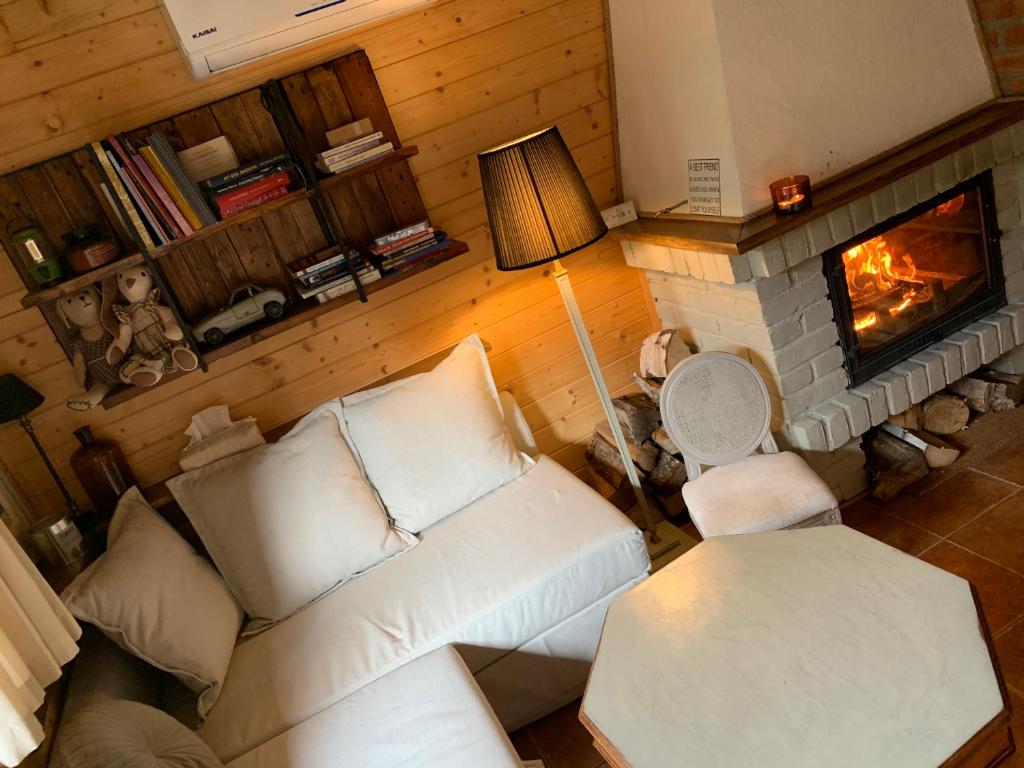 a living room with a white couch and a fireplace at ReverGrand Mazury in Marksoby