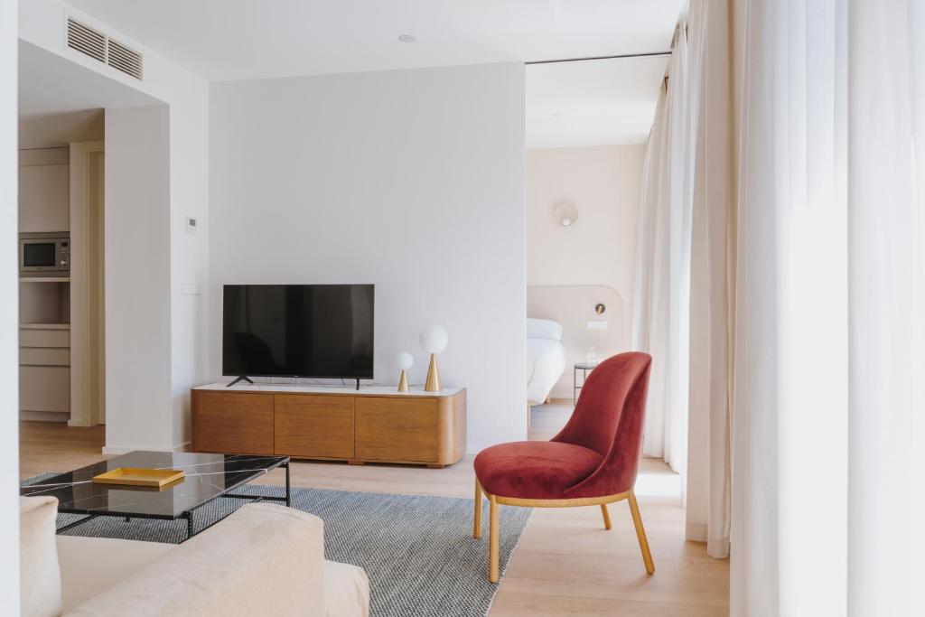 salon z telewizorem i czerwonym krzesłem w obiekcie The Passage Apartments w mieście San Sebastián