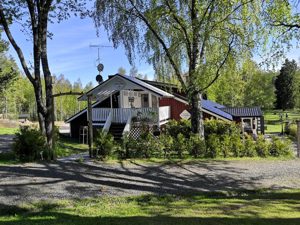 uma casa com um monte de árvores na frente dela em Hostel Mansikka em Taipalsaari