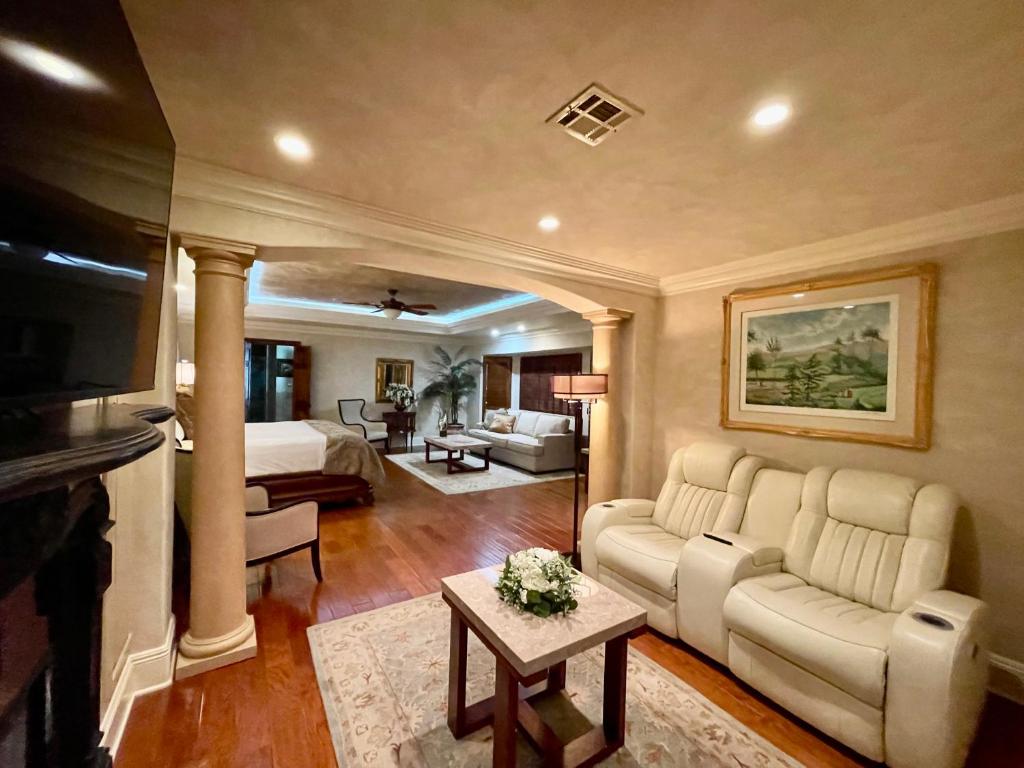 un soggiorno con divano, letto e TV di Louisiana Cajun Mansion a Youngsville