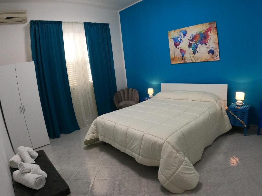 メンフィにあるApartment La Conchigliaの青い壁のベッドルーム1室(大きな白いベッド1台付)