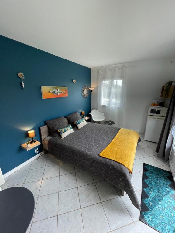 1 dormitorio con cama y pared azul en Chambre calme avec piscine, en Cavagnac