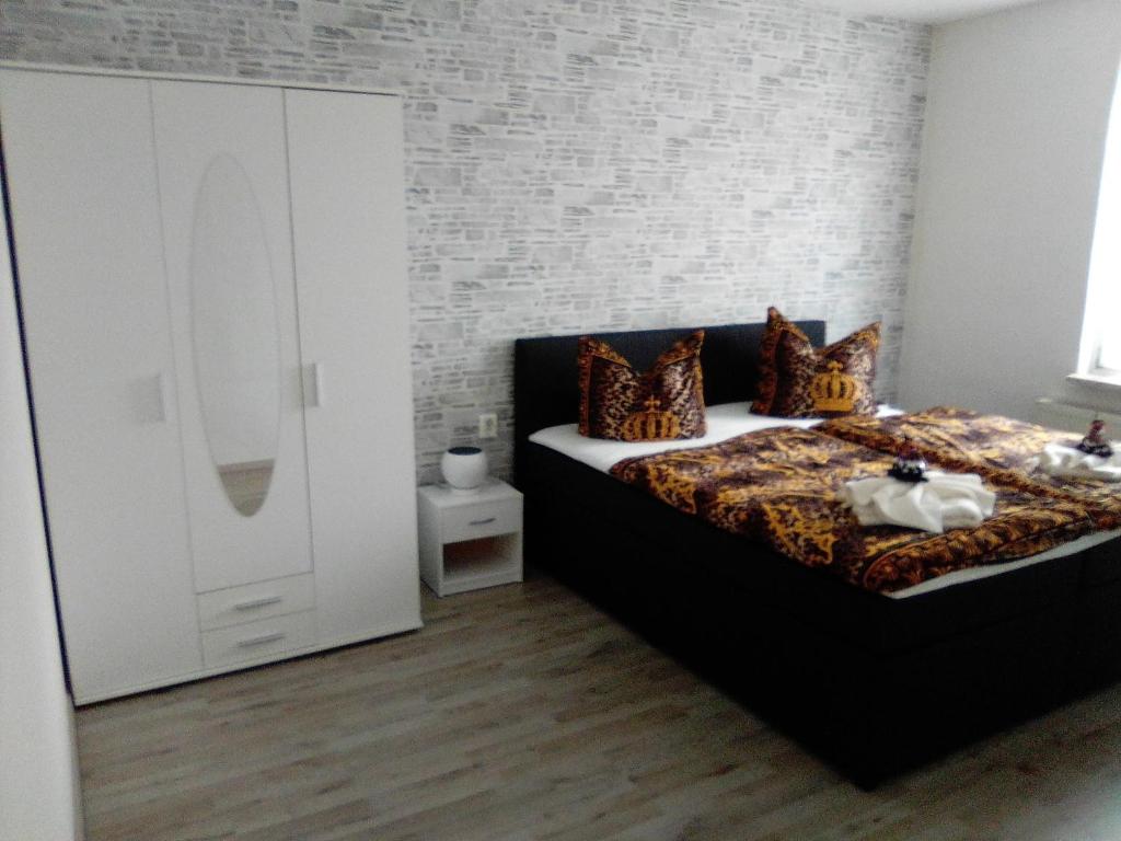 a bedroom with a bed and a white brick wall at Harzhaus in Wienrode
