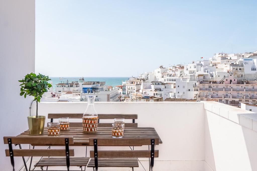 a table on a balcony with a view of a city at Atlantic Breeze Apartments in Albufeira
