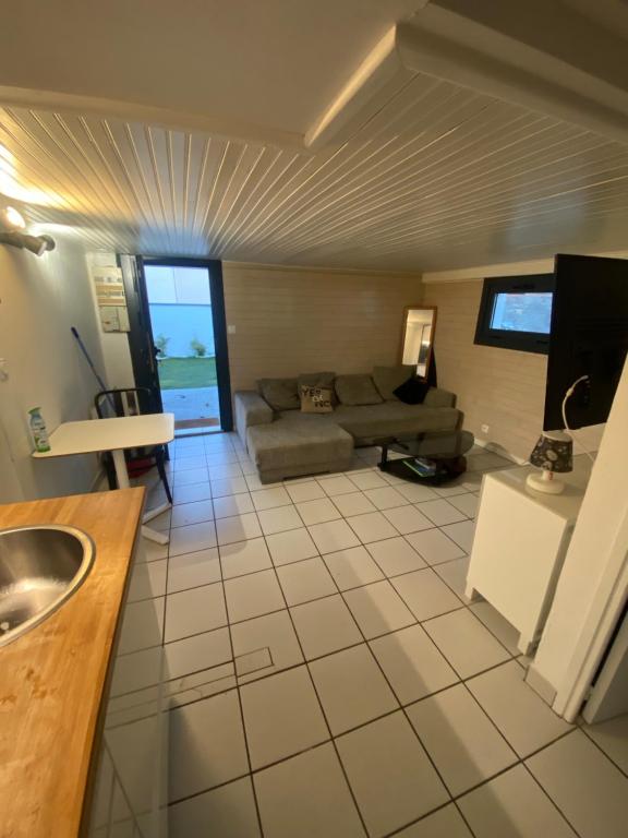 a living room with a couch and a table at COSY APPARTEMENT a UN PAS DE LA PLAGE ET SPOTS DE CAPBRETON in Capbreton