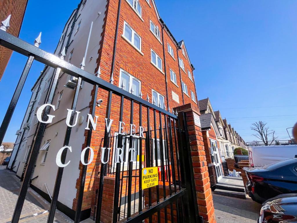 a gate in front of a red brick building at Ilford Luxury Apartments in Ilford
