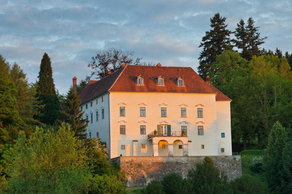 ein großes weißes Gebäude mit rotem Dach in der Unterkunft Schloss Ernegg in Steinakirchen am Forst