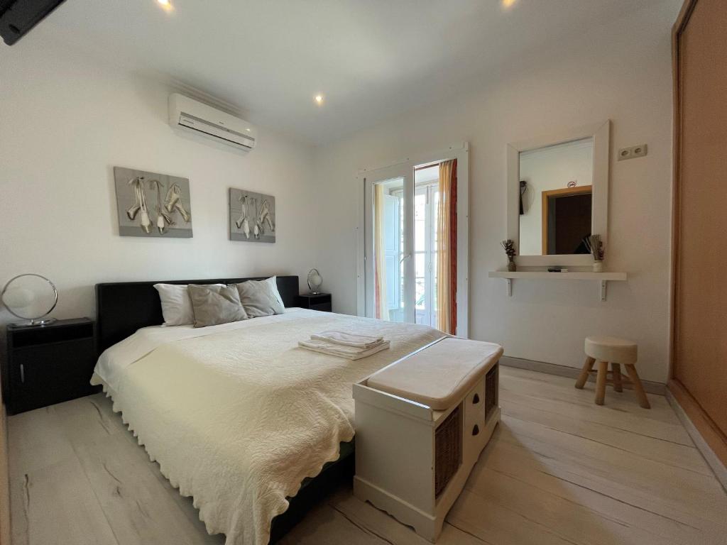 
a bedroom with a bed, a desk and a painting on the wall at Discovery Tavira in Tavira
