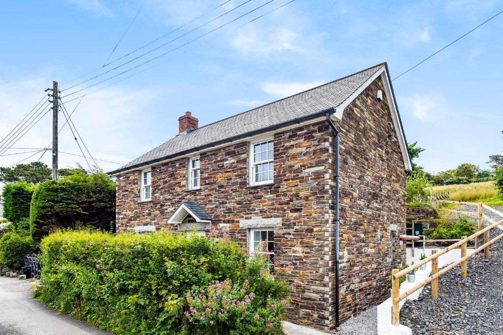 een stenen huis met een gambrel dak bij Eveley Cottage in Boscastle