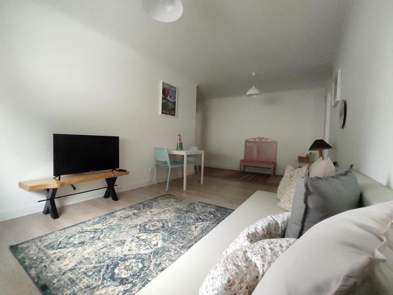 sala de estar con sofá y TV de pantalla plana en City Apartament en Ponta Delgada