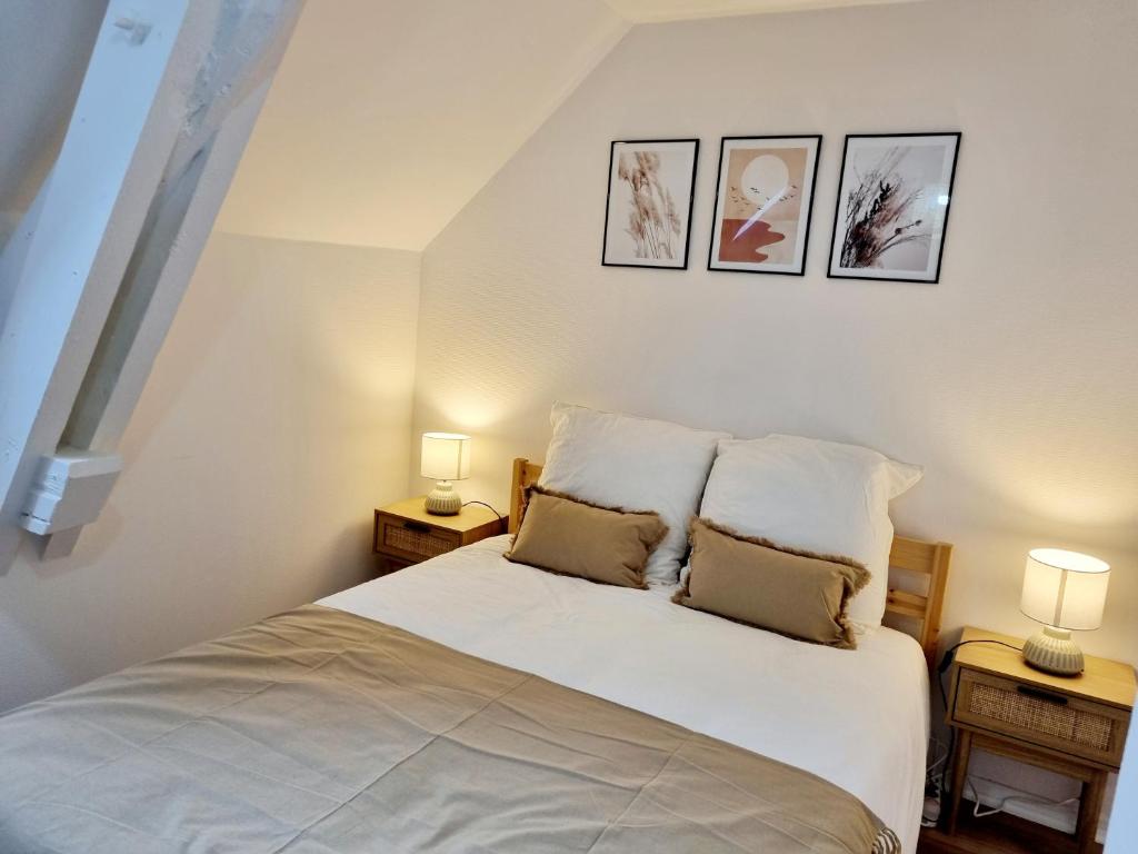 ein Schlafzimmer mit einem weißen Bett mit zwei Lampen in der Unterkunft Meublés du chêne vert, cœur de Jarnac in Jarnac