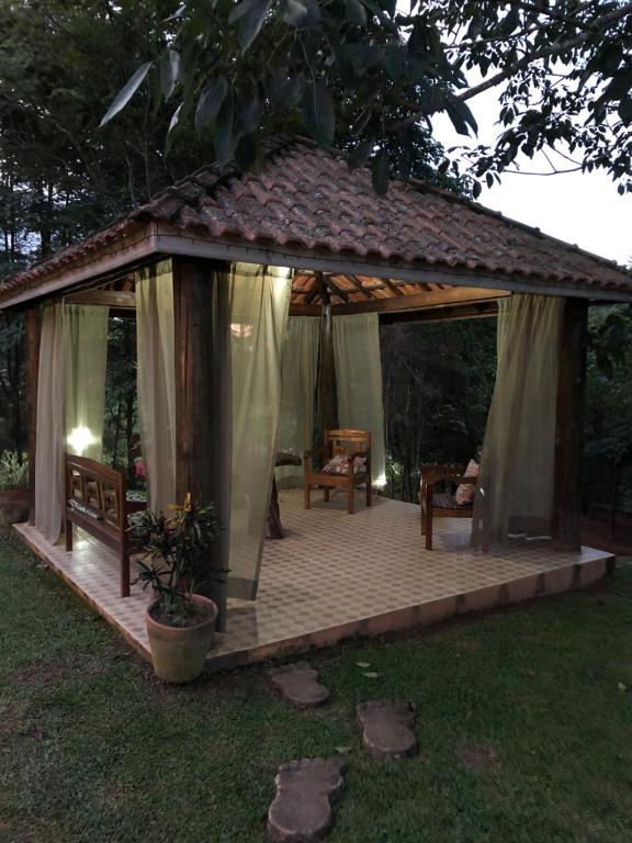 um gazebo com duas cadeiras e uma mesa em Pousada Vale dos Sonhos em Cunha