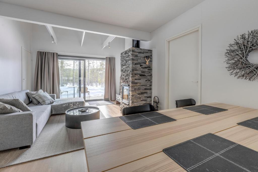 a living room with a couch and a table at Suomu Chalet - two bedroom and loft for 8 in Suomutunturi