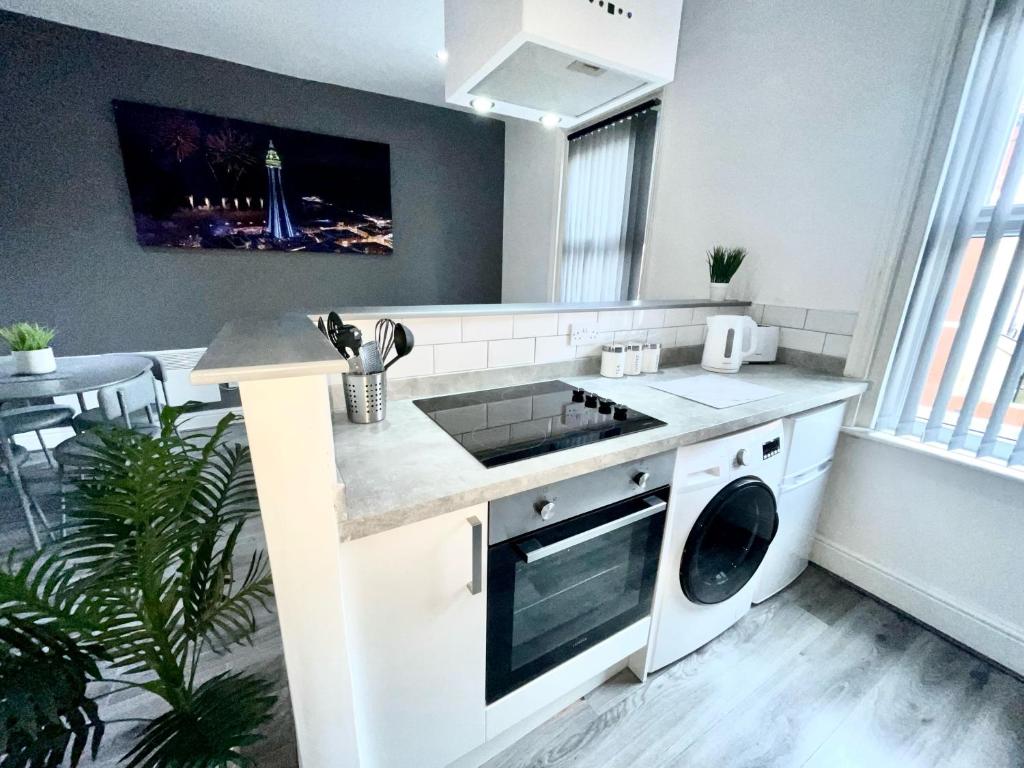 een keuken met een wastafel en een fornuis top oven bij Reads Luxury Jacuzzi Apartments in Blackpool