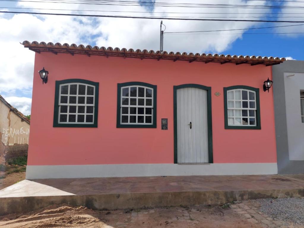 a red house with black windows and a white door at Casa Rio de Contas - Renovada e Ampliada in Rio de Contas