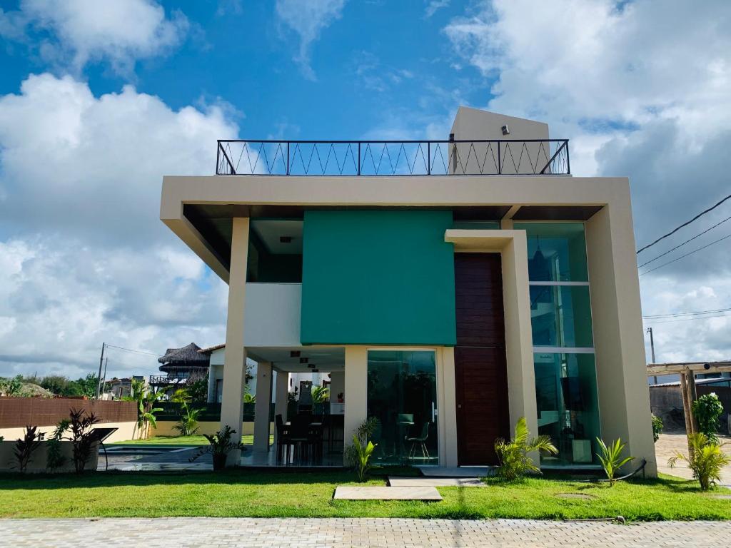 Espetacular Casa de Charme em São Miguel do Gostoso - Salou في ساو ميجيل دو غوستوسو: منزل حديث مع واجهة خضراء