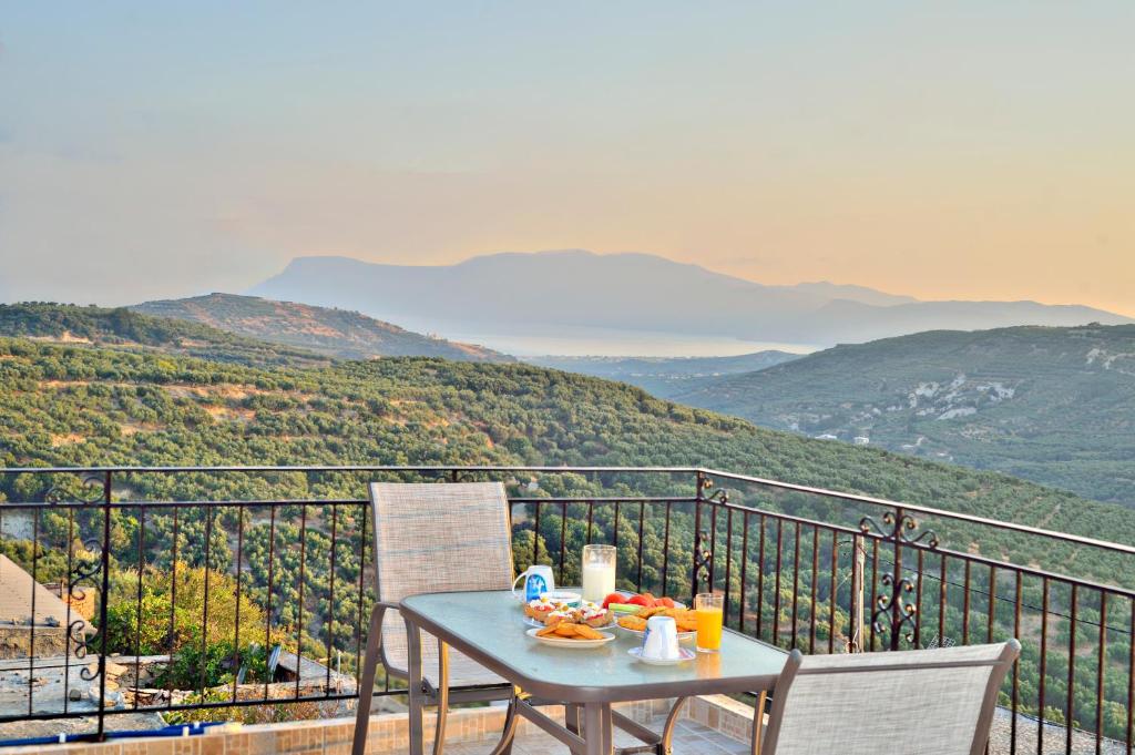 uma mesa com comida no topo de uma varanda com montanhas em Cretan Nature em Kissamos