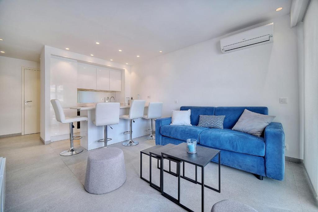 - un salon avec un canapé bleu et une table dans l'établissement IMMOGROOM - Suquet - Terrace - Sea view - Air conditioning, à Cannes