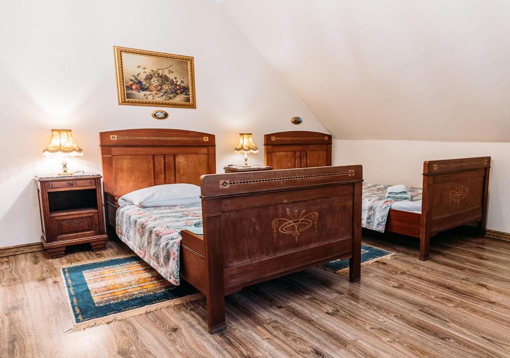 two beds in a bedroom with wooden furniture at Willa Bajka in Inowrocław
