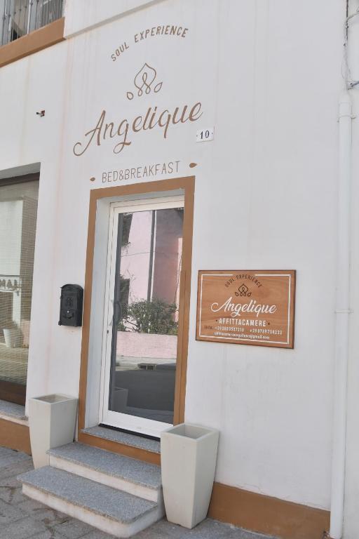 una entrada a una tienda de antwerp con un cartel en ella en Angelique Affittacamere, en Santa Teresa Gallura