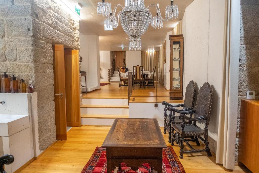 un couloir avec une table et des chaises ainsi qu'une salle à manger dans l'établissement Casa das Ameias, à Vouzela