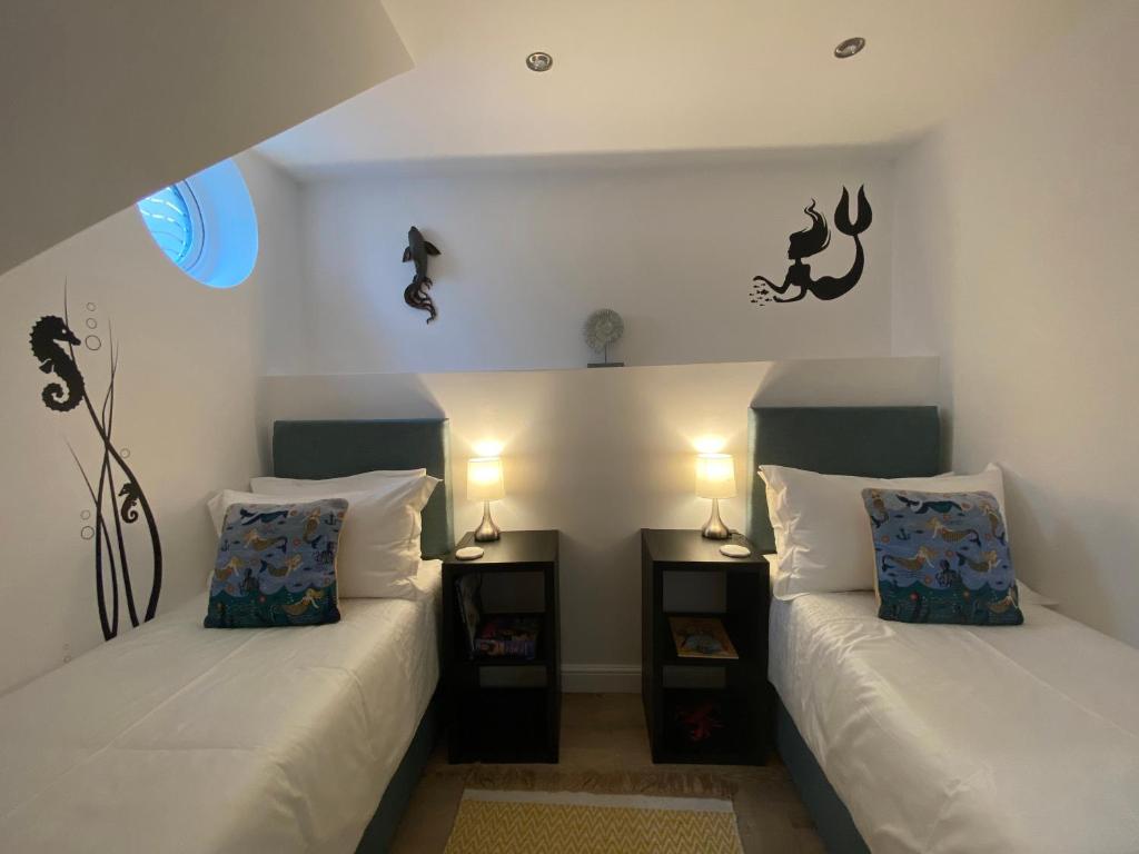 Habitación con 2 camas y 2 mesitas de noche en Starboard Side Brixham - Ideal seaside getaway with parking en Brixham