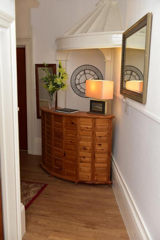 a room with a lamp on a dresser with a mirror at CORBIERE GUEST HOUSE in Weston-super-Mare