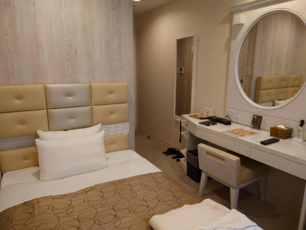 bagno con letto, lavandino e specchio di Hotel Relief SAPPORO SUSUKINO - Vacation STAY 22951v a Sapporo