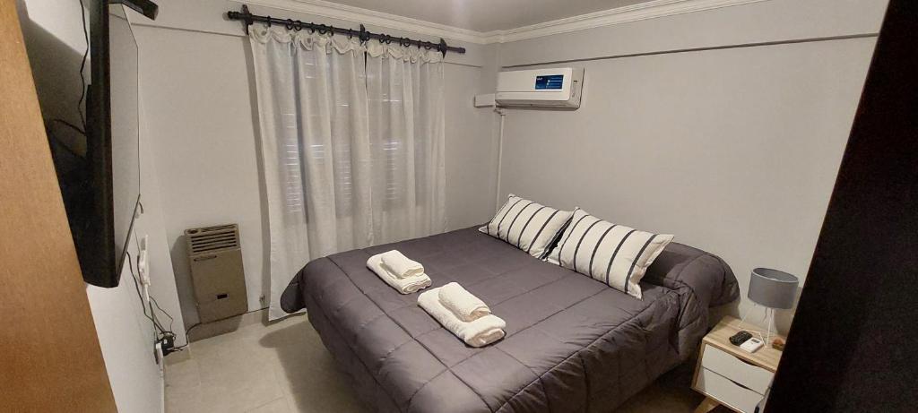 - une chambre avec un lit et 2 serviettes dans l'établissement Departamento 1A Santiago del Estero 80, à Salta