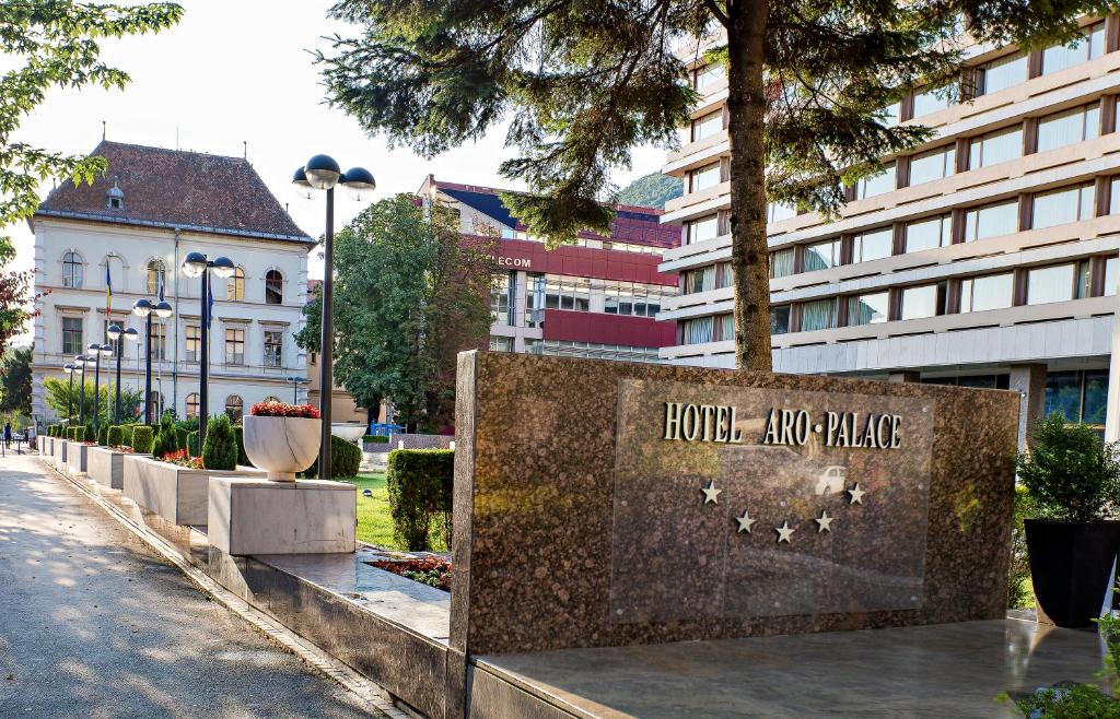 a large brick building with a clock on the side of it at Hotel Aro Palace in Braşov