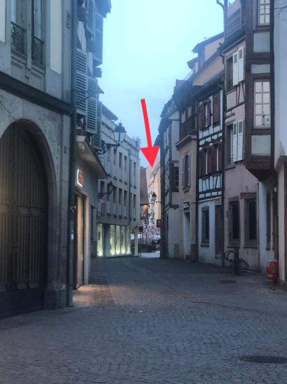 a red arrow is pointing down a street at MAMA with mobile aircon, including free parking space at 300 meters in Colmar