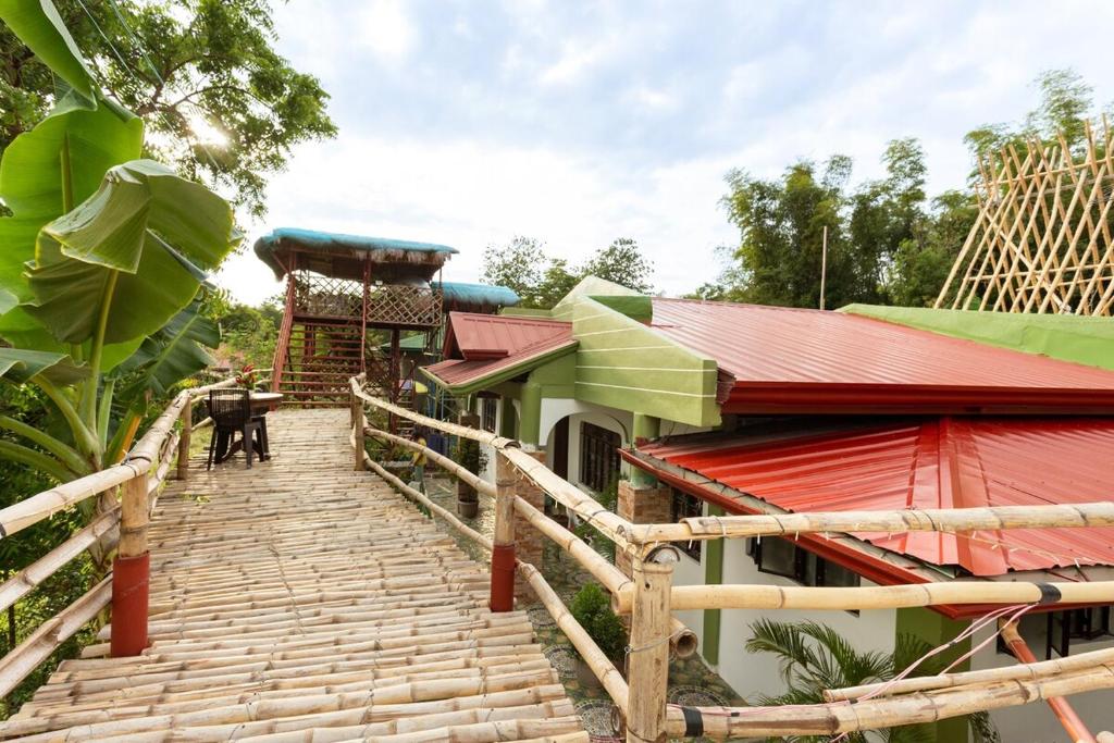 ein Haus mit einer Treppe, die zu einem Gebäude mit roten Dächern führt in der Unterkunft SMyleINN Farm in San Fernando