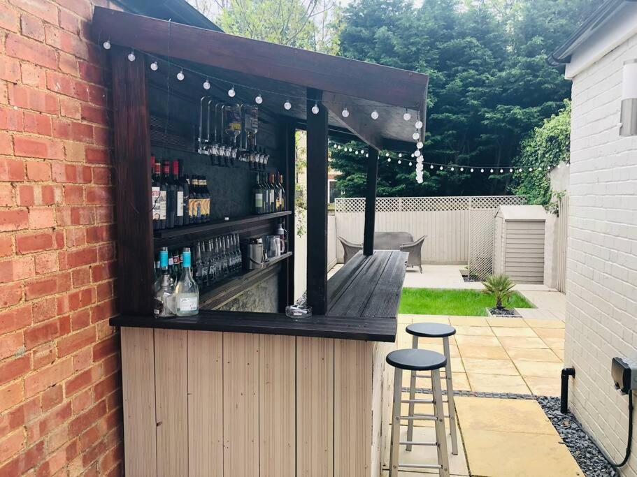 a bar with two stools in front of a brick wall at The Villas, Newly refurbished modern home - Free parking, Prime, Netflix in Buckingham