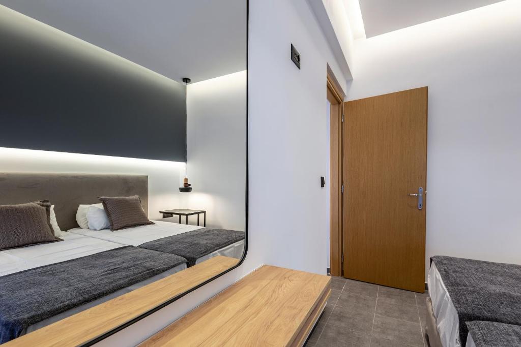 a bedroom with a large bed and a wooden door at Cirillo Family Hotel-Christinas Studios in Mastihari