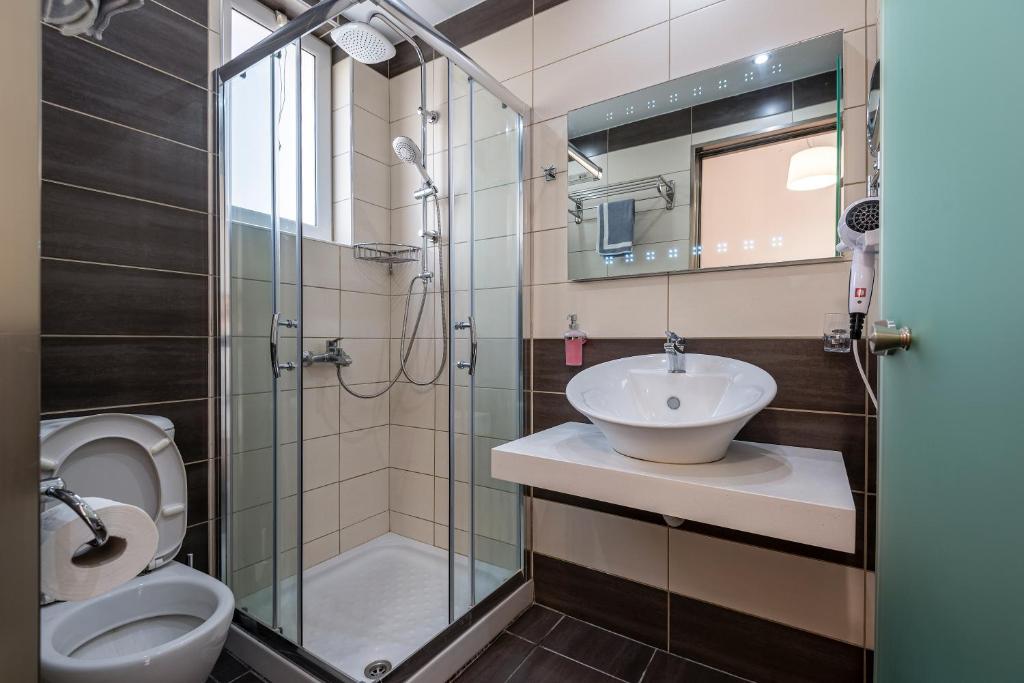 a bathroom with a toilet and a sink and a shower at Cirillo Family Hotel-Christinas Studios in Mastihari