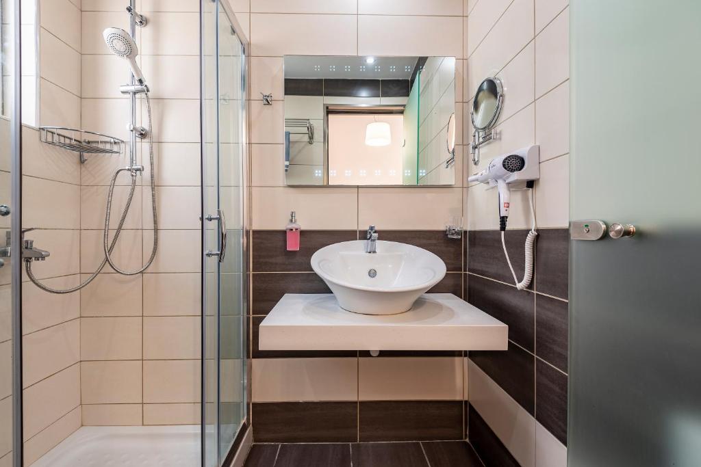 a bathroom with a sink and a shower at Cirillo Family Hotel-Christinas Studios in Mastihari