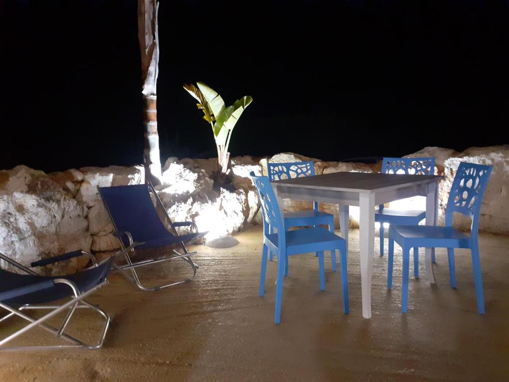 a table and chairs and a table and a plant at casa vacanza ginevra in Marzamemi