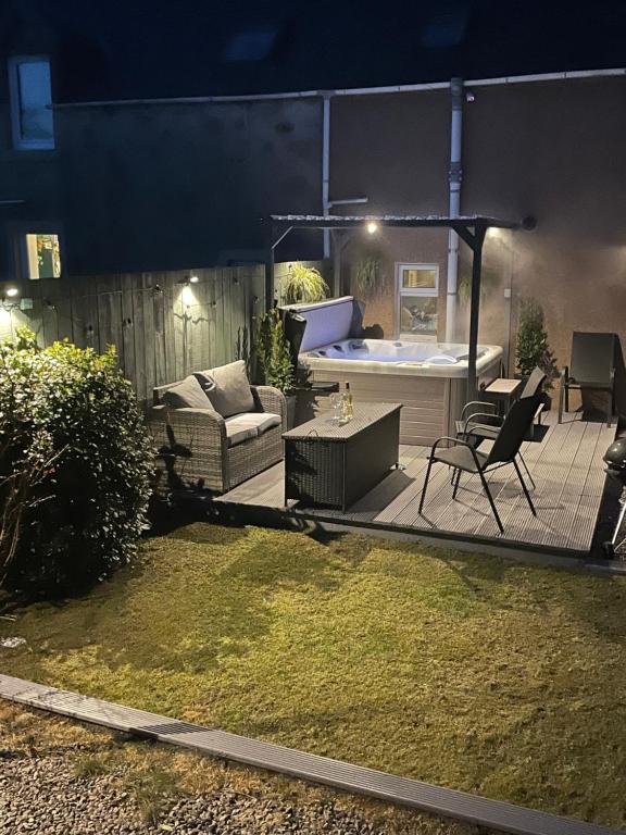 a backyard with a hot tub and a table and chairs at Ardentorrie Holiday Home in Inverness