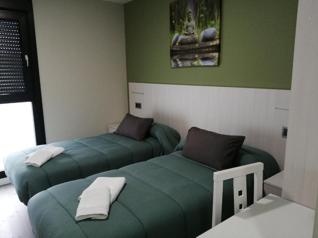 2 camas en una habitación con paredes verdes en PENSION PORTA SANTA en Baleira