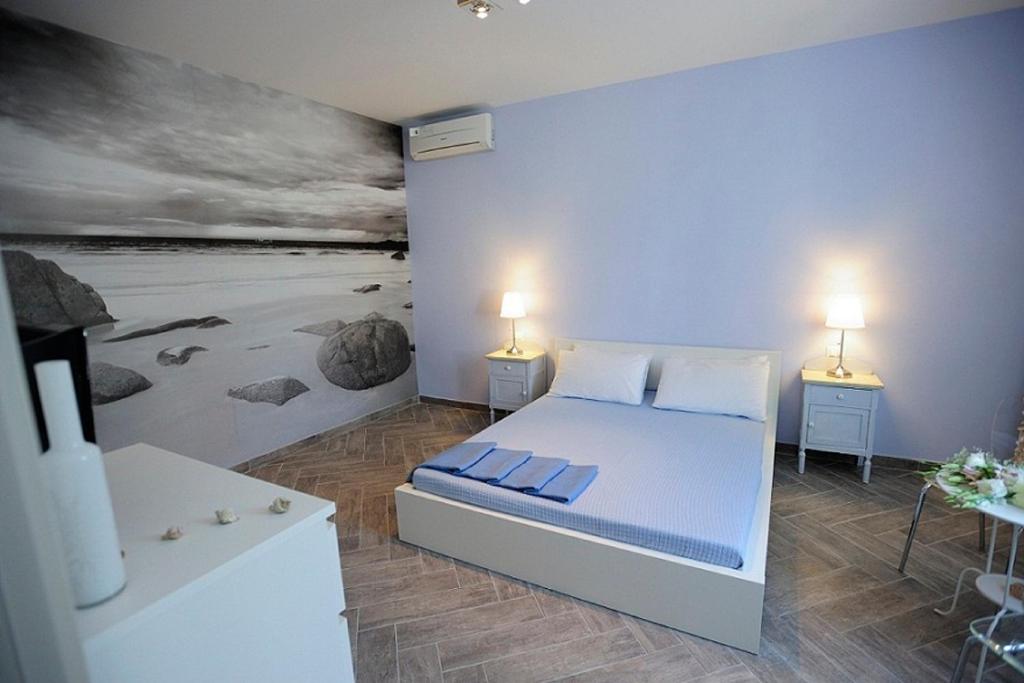 um quarto com uma cama e um quadro na parede em A Babordo B&B em Trapani