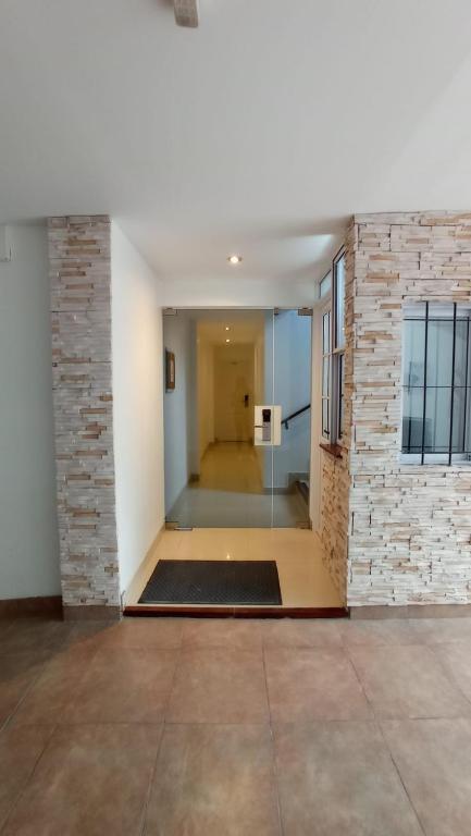 an empty hallway with a brick wall and a door at Hotel Dinastia Boutique in Salta