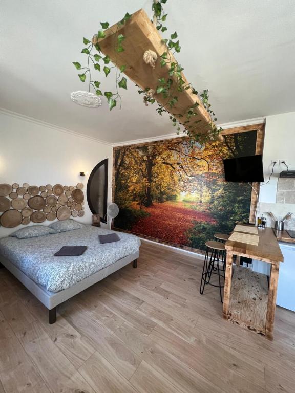 ein Schlafzimmer mit einem Bett und einem Wandgemälde in der Unterkunft Balade en Forêt, 3min du Zoo in Saint-Aignan