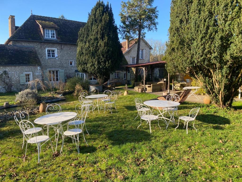 a group of tables and chairs in front of a house at Une Vie en Rose in Pressagny l'Orgueilleux