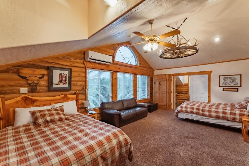 a bedroom with two beds and a ceiling fan at Zion Ponderosa Ranch Resort in Springdale
